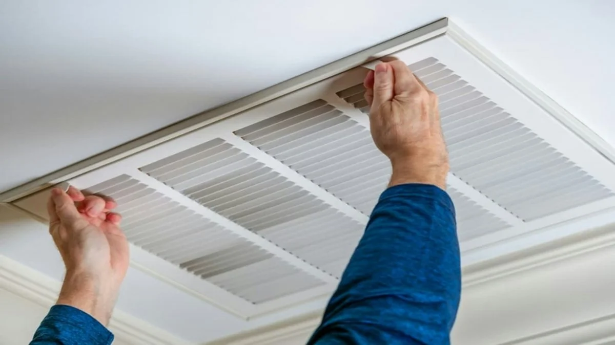 Tehnician holding an air duct component during cleaning or installation in Tucson, Arizona