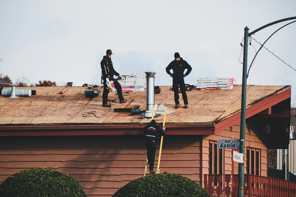 Two roofing workers performing emergency roof repair on a residential home in Tucson, Arizona