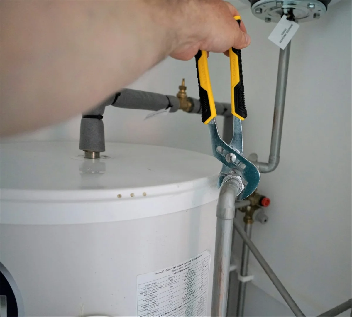 Tehnician repairing a water heater unit in a residential setting in Tucson, Arizona