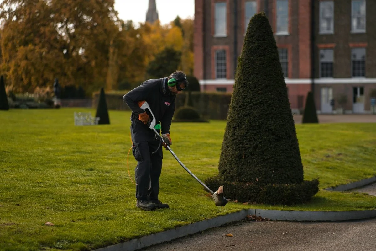 Landscaping worker mowing grass in a commercial yard in Tucson, Arizona
